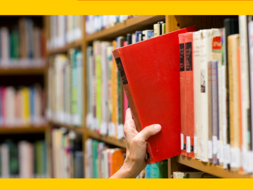 hand pulling book from library shelf
